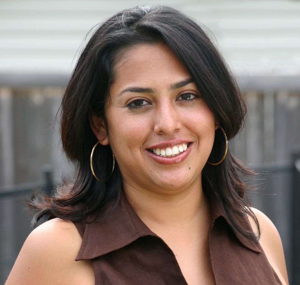 Single woman wearing brown shirt smiling at camera